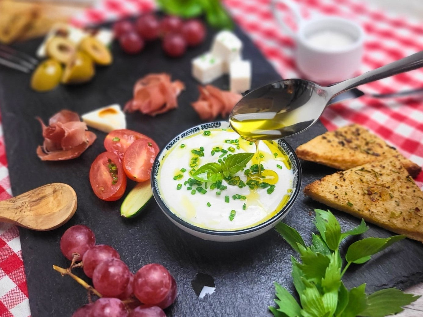 Eine gemischte Picknick-Platte mit Tapas, Häppchen bzw. Fingerfood. Ein herzhafter Dip mit Traubenkernöl.